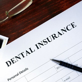 Dental insurance form sitting on a desk with glasses