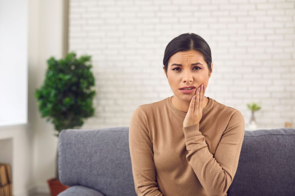 A woman experiencing wisdom tooth pain